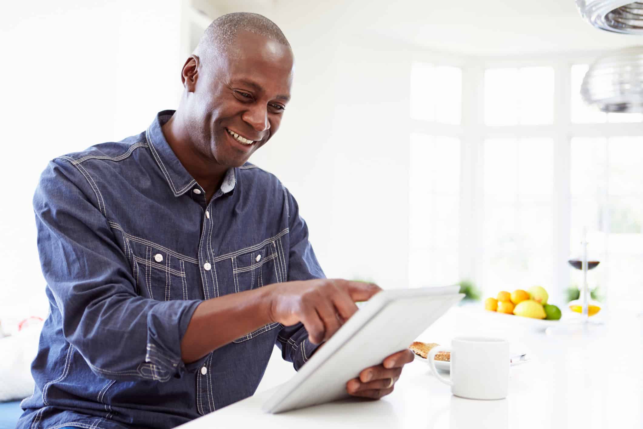 Man sitting at his kitchen counter putting these online dating tips for men to work.