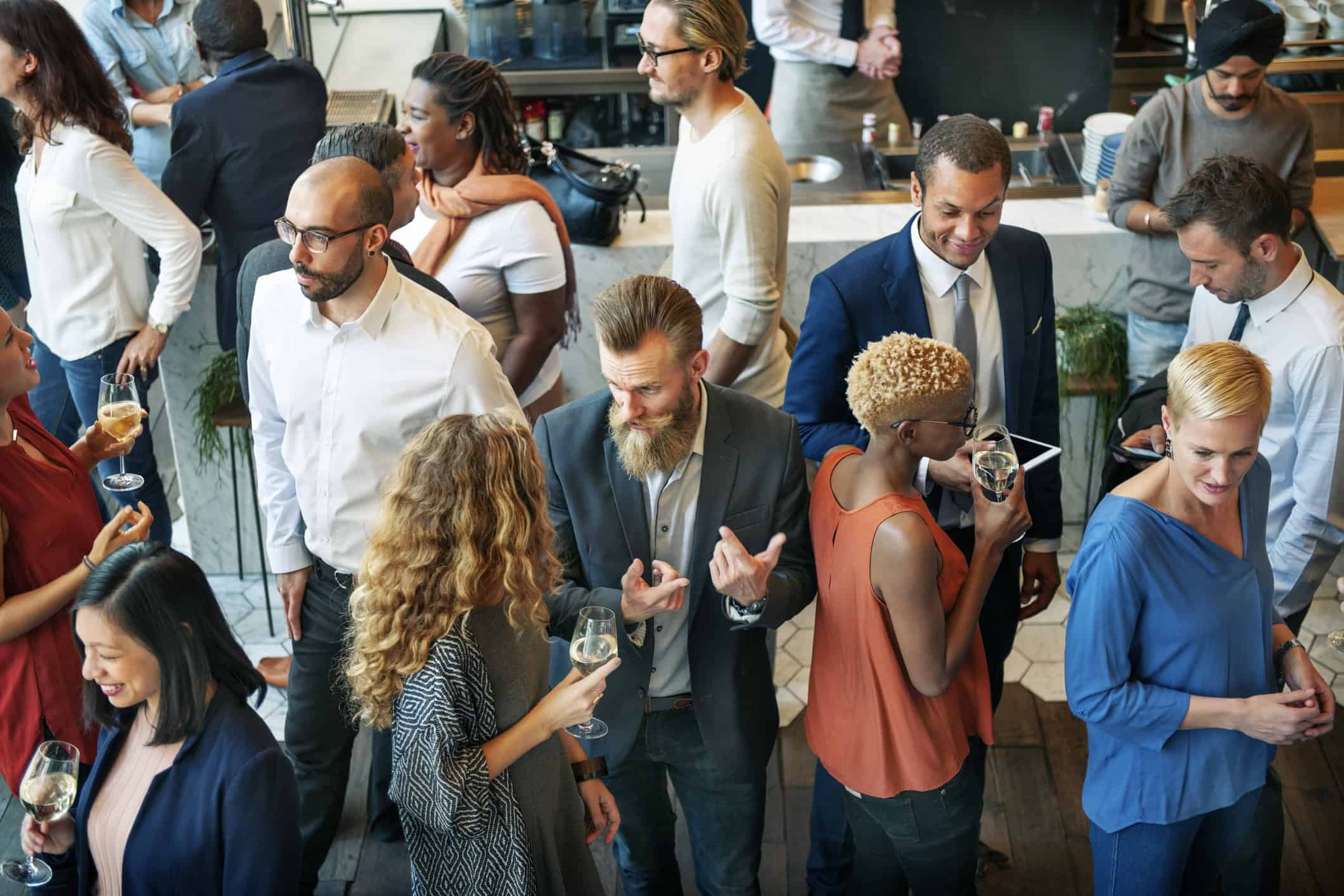 Group of people mingling at a singles event who are making dating a priority in their lives.