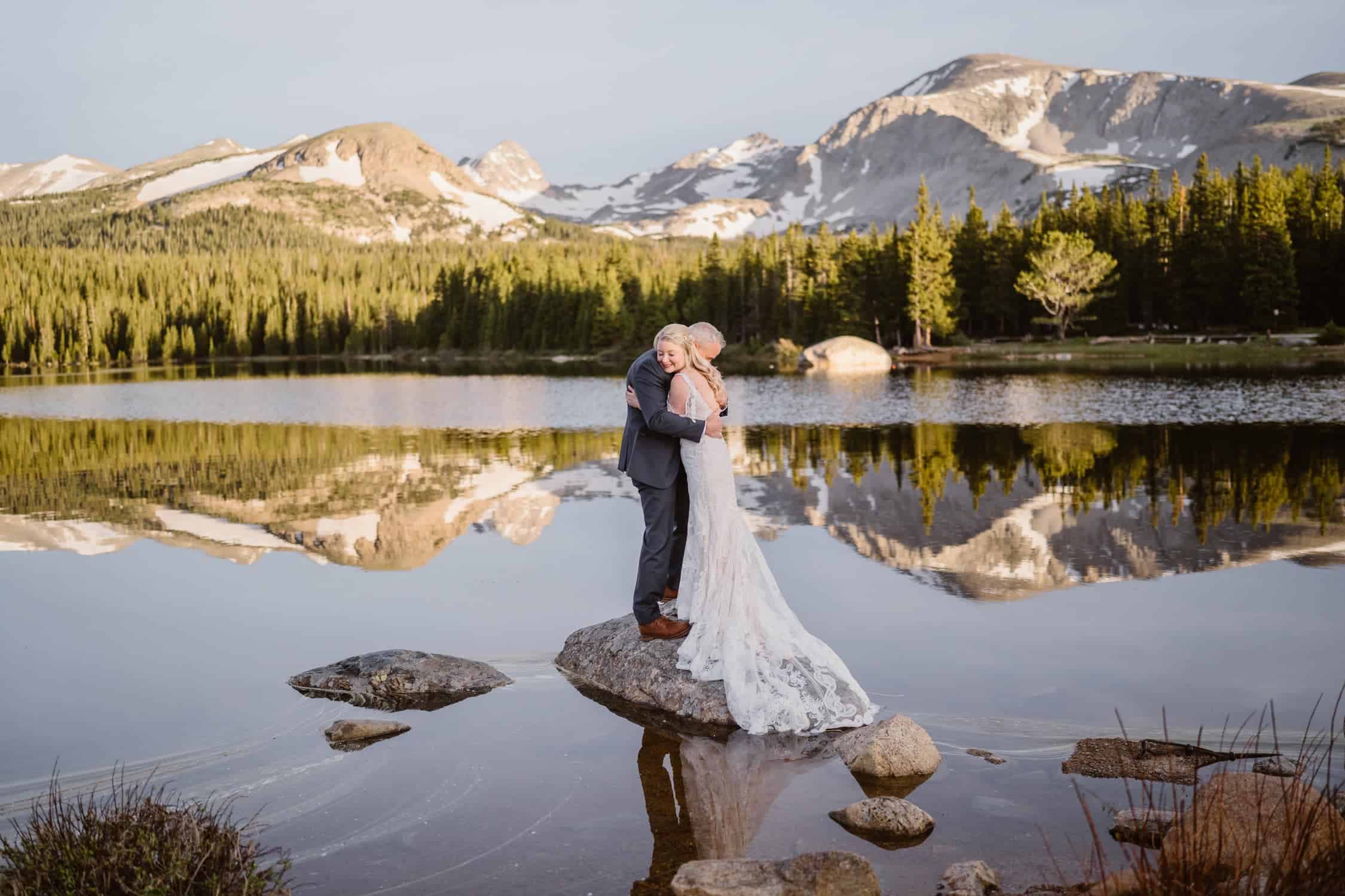 A couple standing on a rock with reflection on the lake in Colorado.,