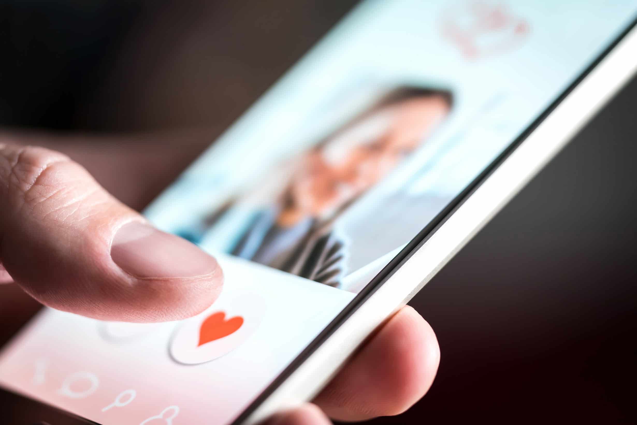 A man looking at an online dating site profile on a niche dating app.
