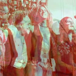 People celebrating at a music event with vibrant lighting and festive atmosphere in the background.