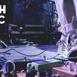 Performing youth musician on stage with guitar effects pedals and sound equipment, emphasizing youth music, live performance, and musical creativity for youth music enthusiasts.