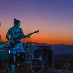 A band performing live at sunset outdoors, showcasing music, musicians, instruments, guitar, bass, drums, sunset scenery, and outdoor concert, perfect for music enthusiasts and live performance lovers.