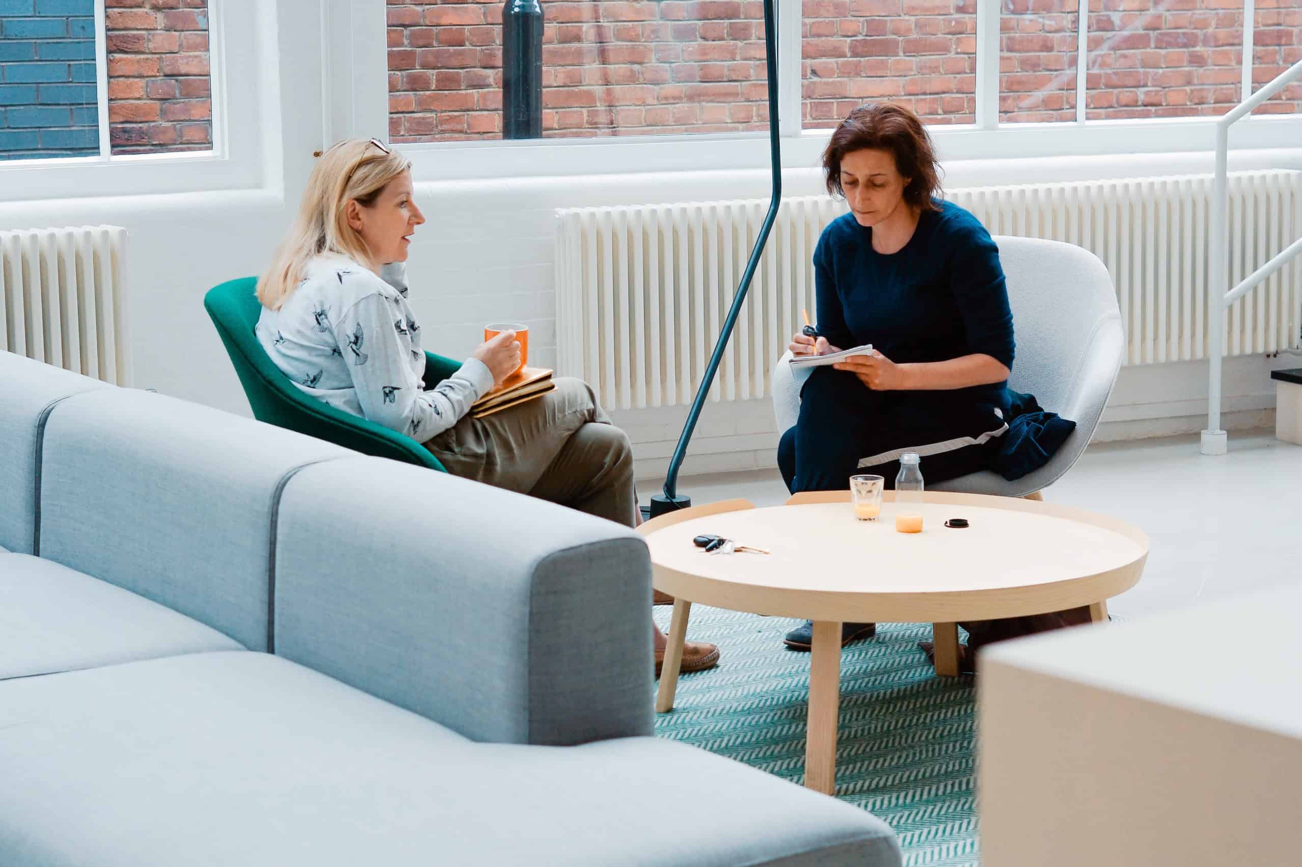 Women sitting in a comfortable room discussing what does a dating coach do.