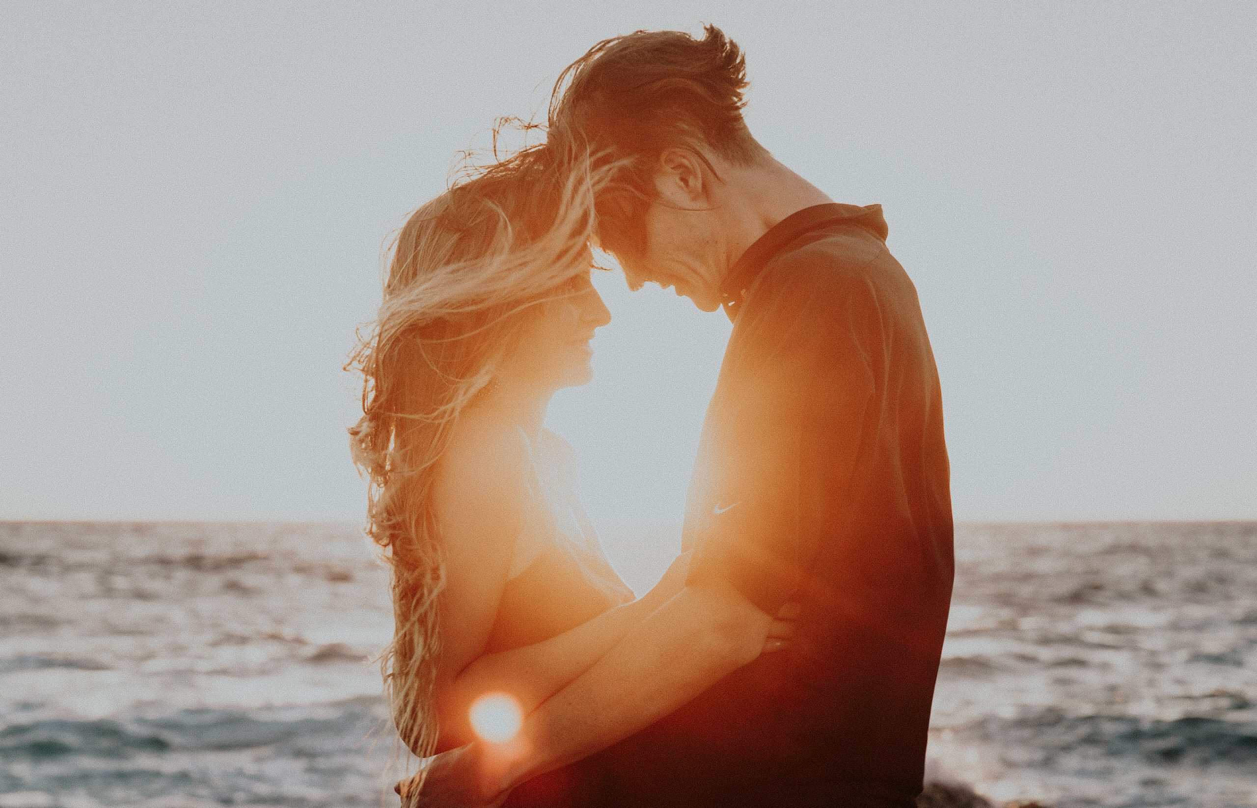 A happy couple hugging because they know the secret to navigating each stage of love.
