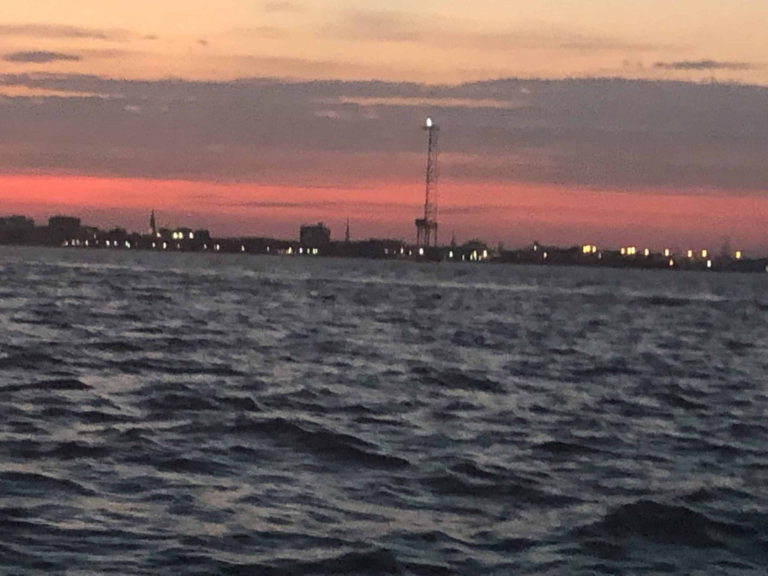 Pink sunset over city horizon. Sunset cocktail cruise Charleston, SC