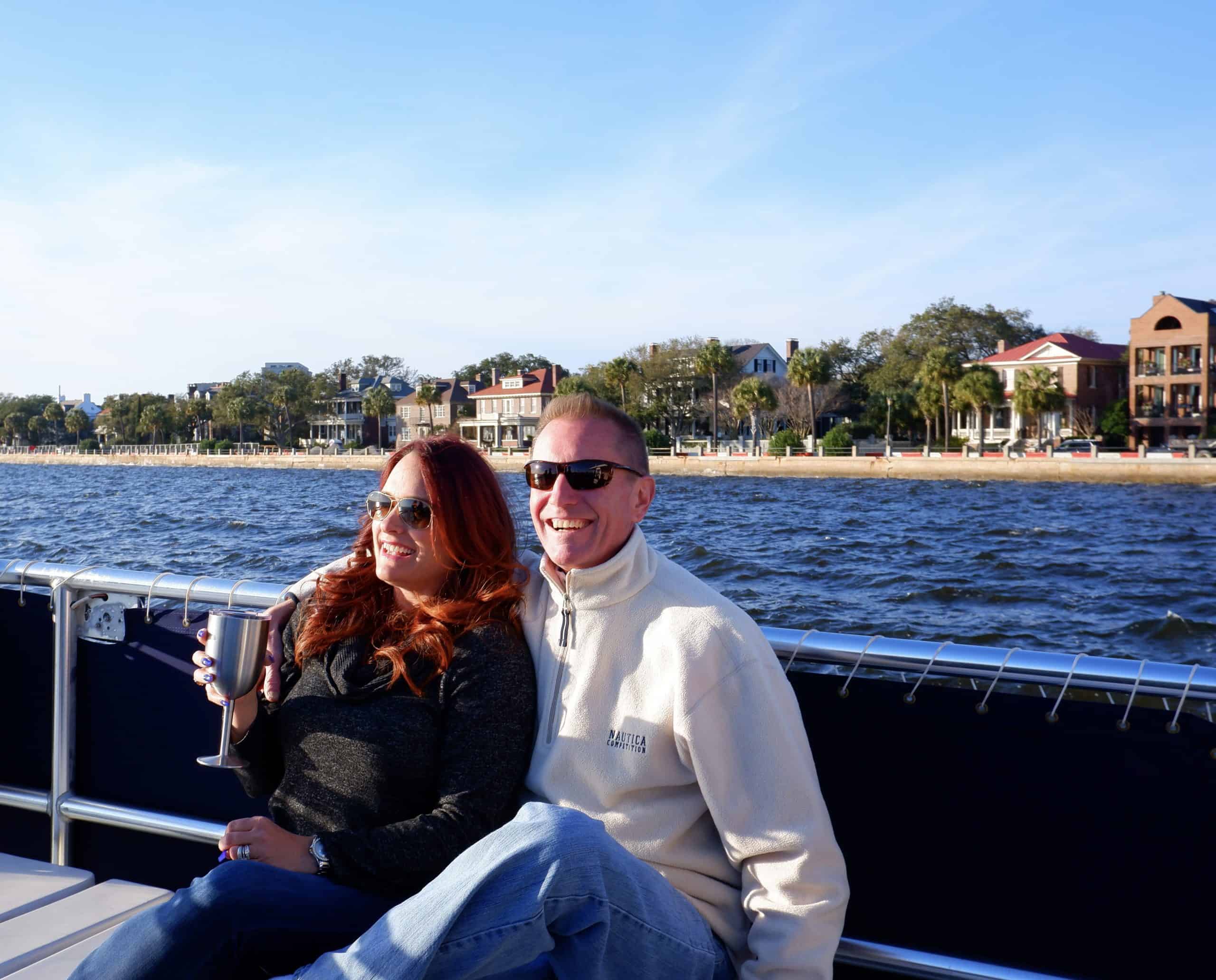 Couple pictured on the boat with The Battery in the background. Party boat rental Charleston, SC