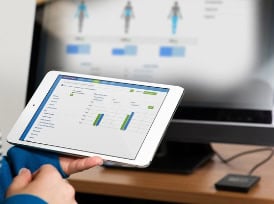 Person holding tablet displaying analytics dashboard charts