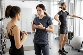 Personal trainer instructing client in modern gym