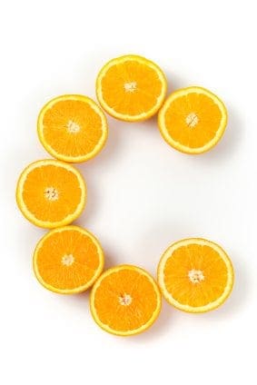 Several pieces of fresh oranges in the form of letter C. Isolated on white.