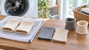 木の台に並べた白とグレーのリブ編みの布と洗濯ネット
