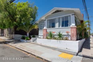 Light grey Craftsman bungalow at 3164 Thorn St in North Park with red brick pillars and a white retaining wall planter.