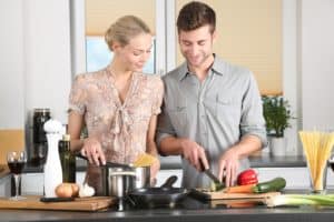 A man and woman are preparing flavorful Polish cuisine in a kitchen.