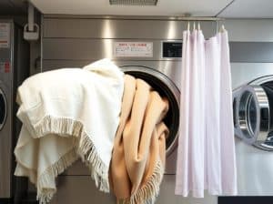 大型洗濯機で洗われる毛布とカーテン