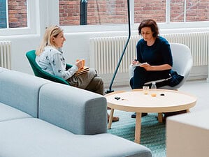 Women sitting in a comfortable room discussing what does a dating coach do.