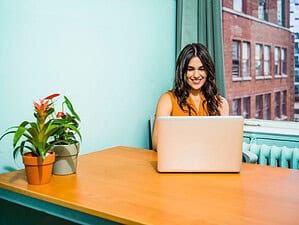 Woman at her laptop researching how to find a dating coach.