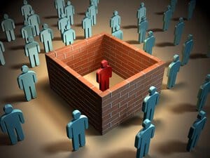 Uma pessoa em vermelho isolada de outras, azuis, por um mudo de tijolos quadrado