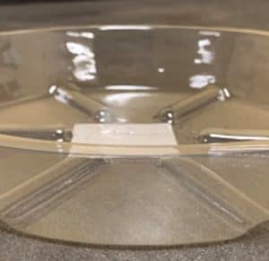 Clear empty plastic container with a lid on a table.
