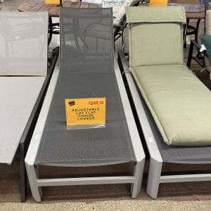 Three lounge chairs displayed for sale, one with a discount sign.