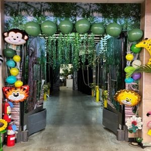 Colorful jungle-themed entrance decorated with balloons and animal faces.