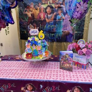 A colorful 6th birthday cake with a Dreamer theme and decorations.