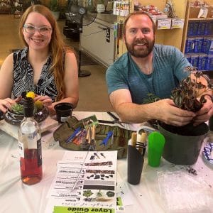 Two people smiling at a table with colorful butterflies and drinks.