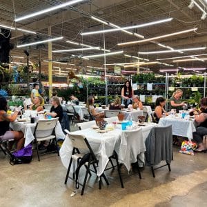 People dining at tables inside a spacious indoor market or event space.