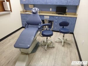 Dental operatory with patient chair, delivery unit, cabinetry, and assistant stools, equipment valued in a dental equipment appraisal.