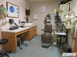 Optometry exam lane with exam chair, phoropter, slit lamp, and instrument stand, equipment valued in an optometry equipment appraisal.