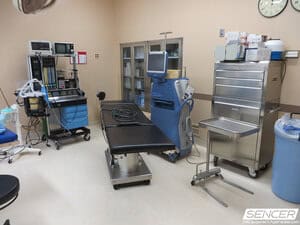 Operating room with an anesthesia machine, patient monitor, surgical table, and instrument storage, equipment valued in a surgical equipment appraisal.