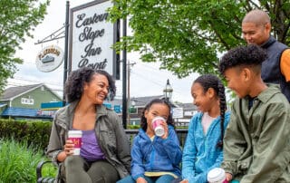 family drinking beverages outside eastern slope inn