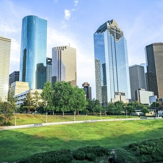 Downtown Houston skyline with glass skyscrapers and green park space — reflecting the urban development environments where EDGE Engineering provides environmental permitting and compliance services.