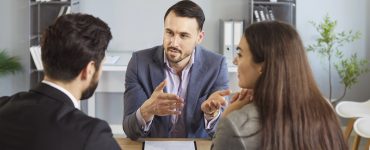 image of couple meeting with lawyer for a post about 10 reasons why aspiring franchisees need a franchise attorney