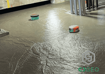 CJFill-Standard cellular concrete poured around pipes and columns in a basement.