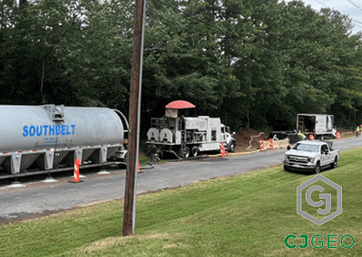 a semi, cement pig, batch plant and pickup truck on a roadside pipe abandonment jobsite