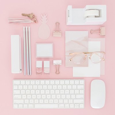 organized white office supplies on pink desktop