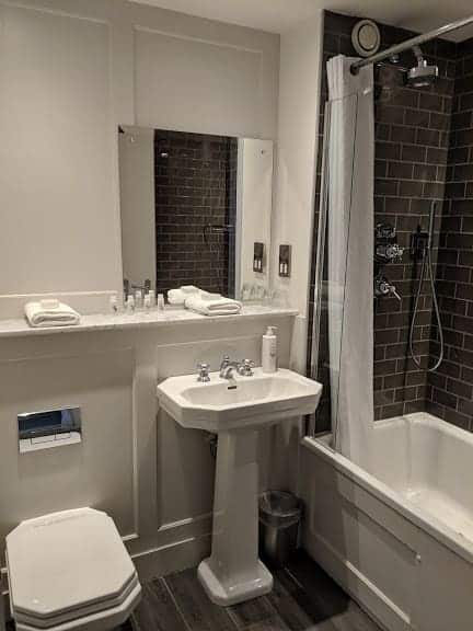 A black and white modern bathroom with a white suite