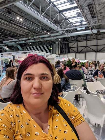 A Selfie of Jen taken at This Morning Live with people sitting at tables in the background chatting