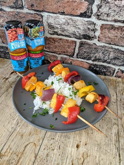 Kebabs and rice on black plate