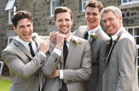 Groomsmen in grey suits smiling