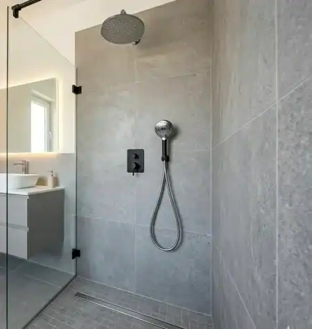 Modern épített zuhanyzó kivitelezése lineáris lefolyóval és csúszásmentes burkolattal