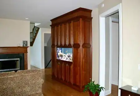 Living room with dark wood TV unit showing aquarium scene and fireplace