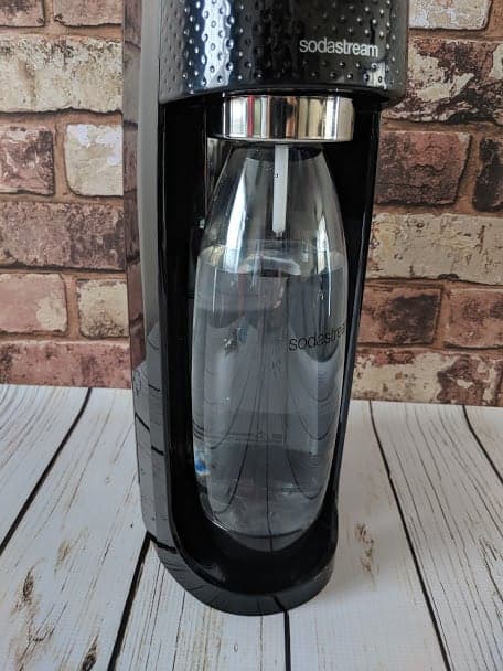 Sodastream Spirit on wooden surface in front of brick wall