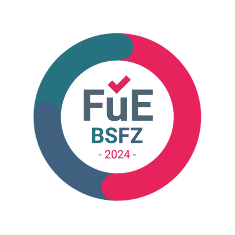 Kreisförmiges Logo mit blauen und rosa Segmenten, Text „FuE BSFZ 2024“ in der Mitte und einem roten Häkchen über dem „u“.
