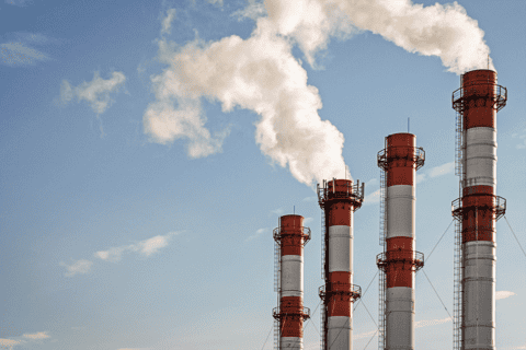 Industrial smokestacks emitting white steam or exhaust plumes against a blue sky — power plant or manufacturing facility air emissions subject to EPA Clean Air…Industrial smokestacks emitting white steam or exhaust plumes against a blue sky — power plant or manufacturing facility air emissions subject to EPA Clean Air Act permitting, stack testing, and emissions monitoring compliance consulting by EDGE Engineering.
