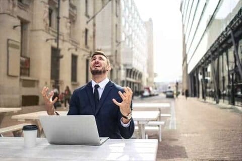 Ein nervöser Mann arbeitet an seinem Laptop
