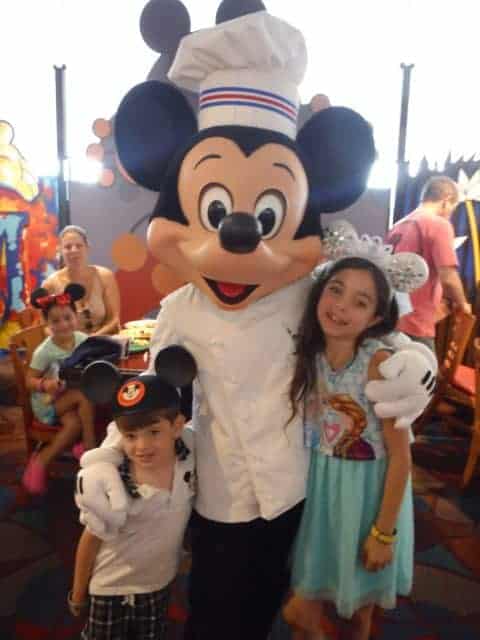 Jackson and Bella get their picture taken with Chef Mickey in his white coat and chef's hat