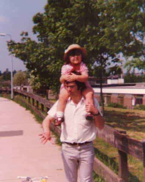 A young girl sitting on her father\'s shoulders