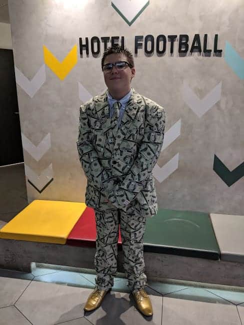 Ben in a suit covered in dollar bills