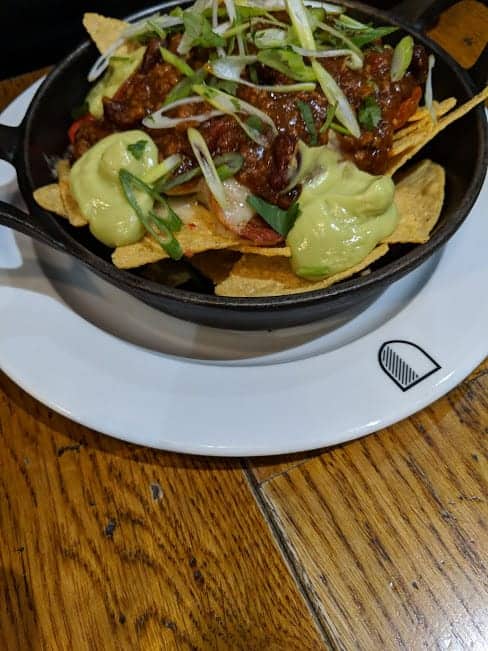 nachos in a skillet on a white plate.